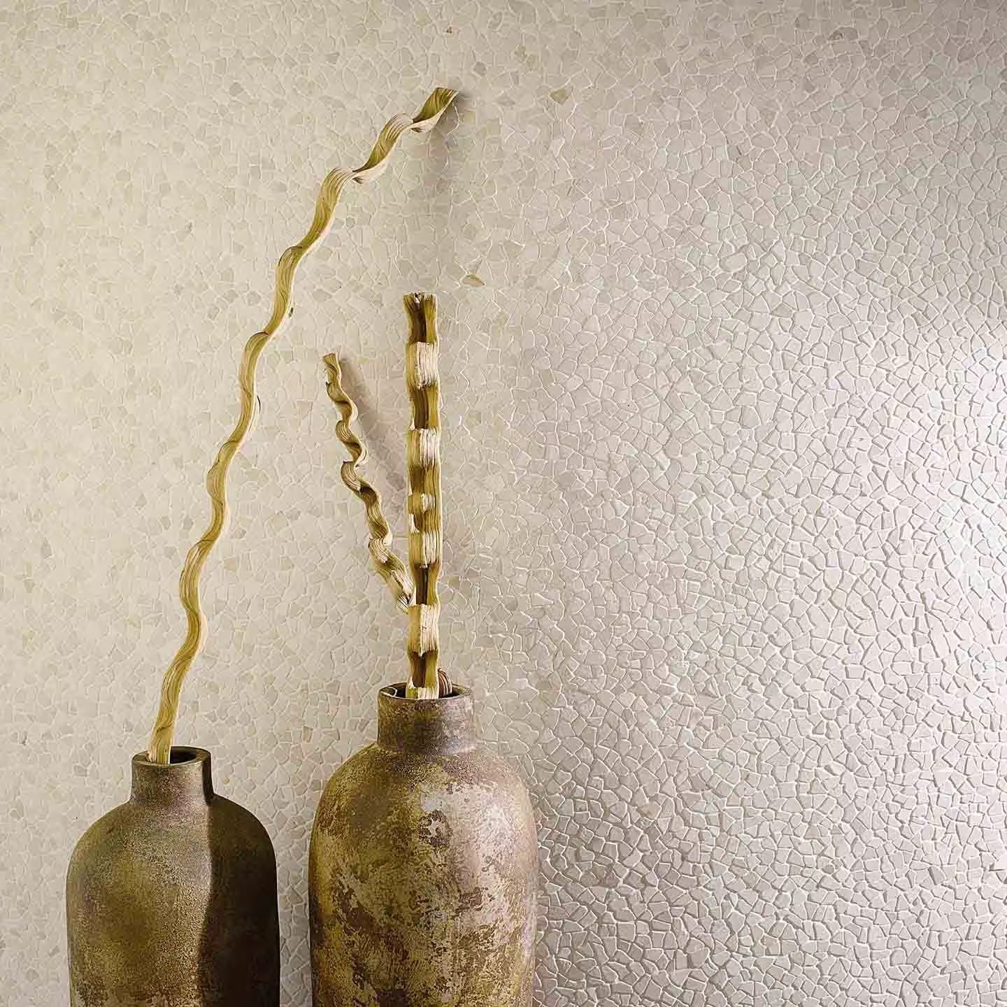 Two rustic metallic vases with aged bronze finish holding twisted dried branches in paradise tiny broken edge blanco mosaic