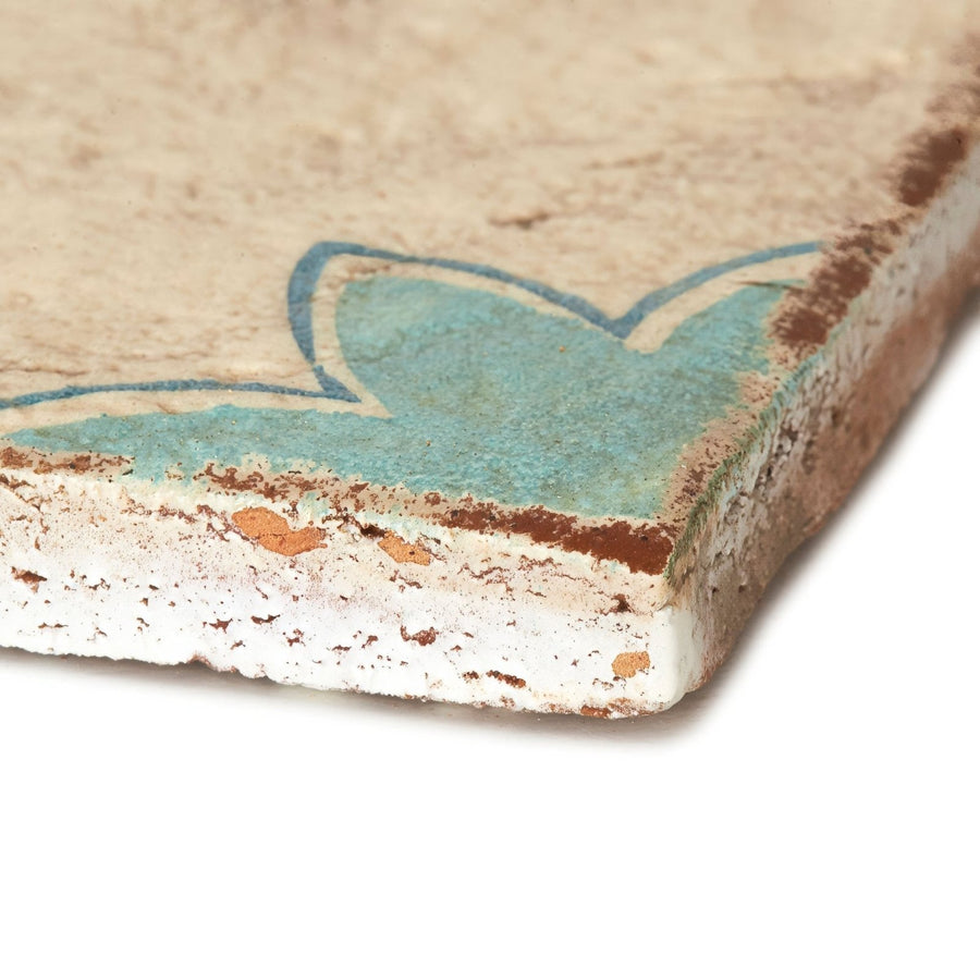Paris Sandrine rustic beige ceramic tile with faded turquoise floral design and chipped weathered edges
