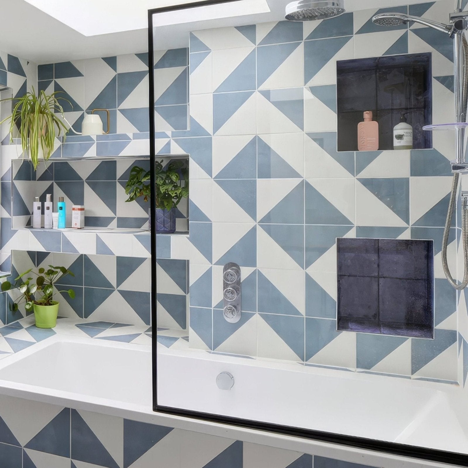 Blue and white geometric patterned porcelain bathroom tiles with inset shelves from parisian café tri blue collection