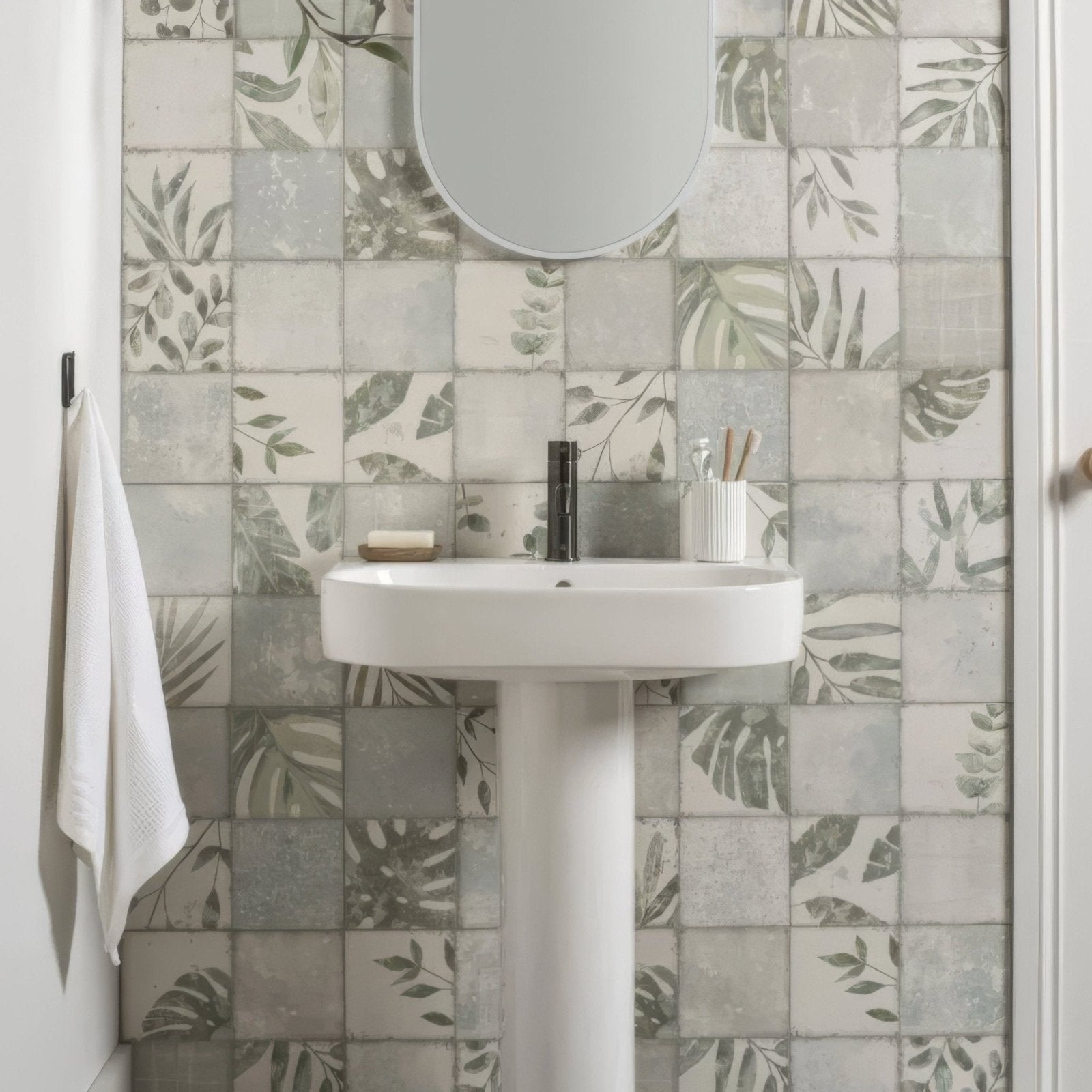 White pedestal sink with sleek modern design and matte black faucet featured in patchwork botanical iris 60x30cm