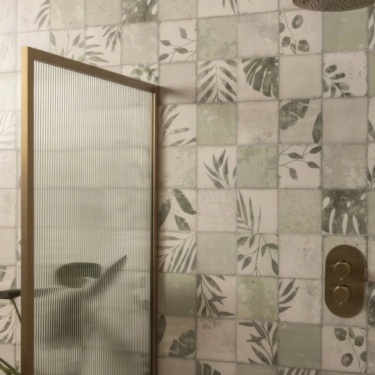 Gold-framed shower screen with vertical frosted glass panels featuring patchwork botanical ivy design 60x30cm
