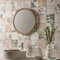 Round wooden-framed mirror mounted on a wall with patchwork botanical rose patterned tiles 60x30cm