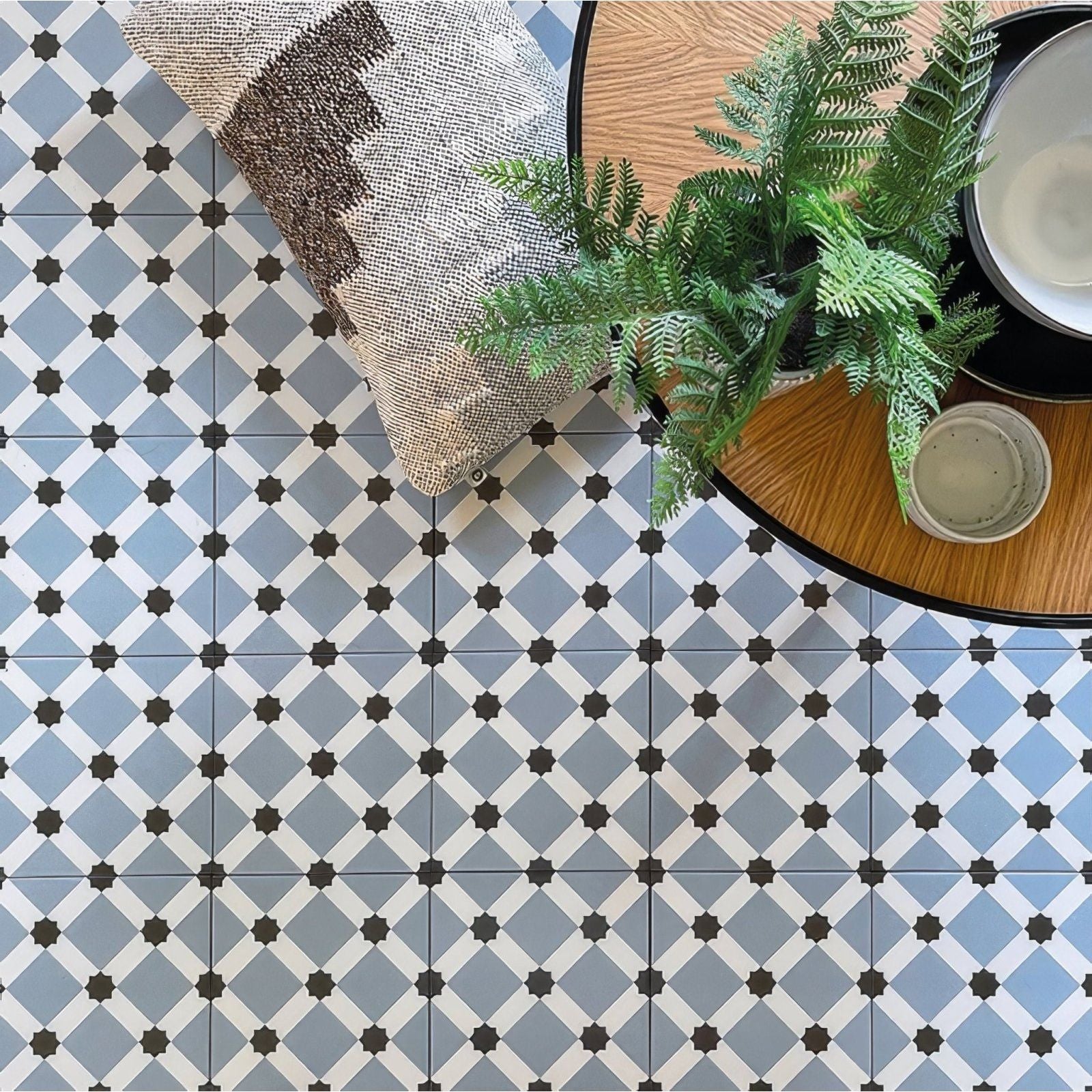Patisserie hevin blue patterned tile featuring blue and white geometric designs with black star shaped accents on floor tiles