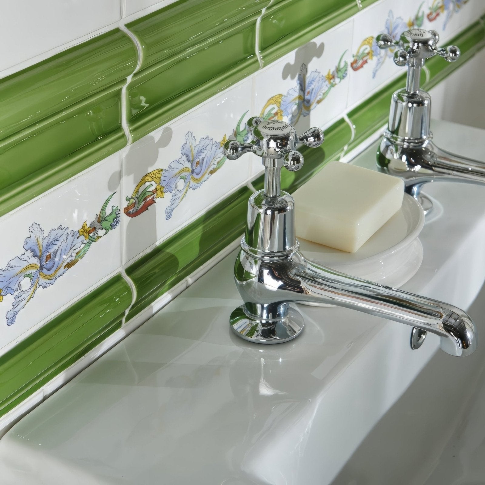 Chrome-finished cross-handle bathroom faucet with polished reflective surface from pavilion green albert moulding collection