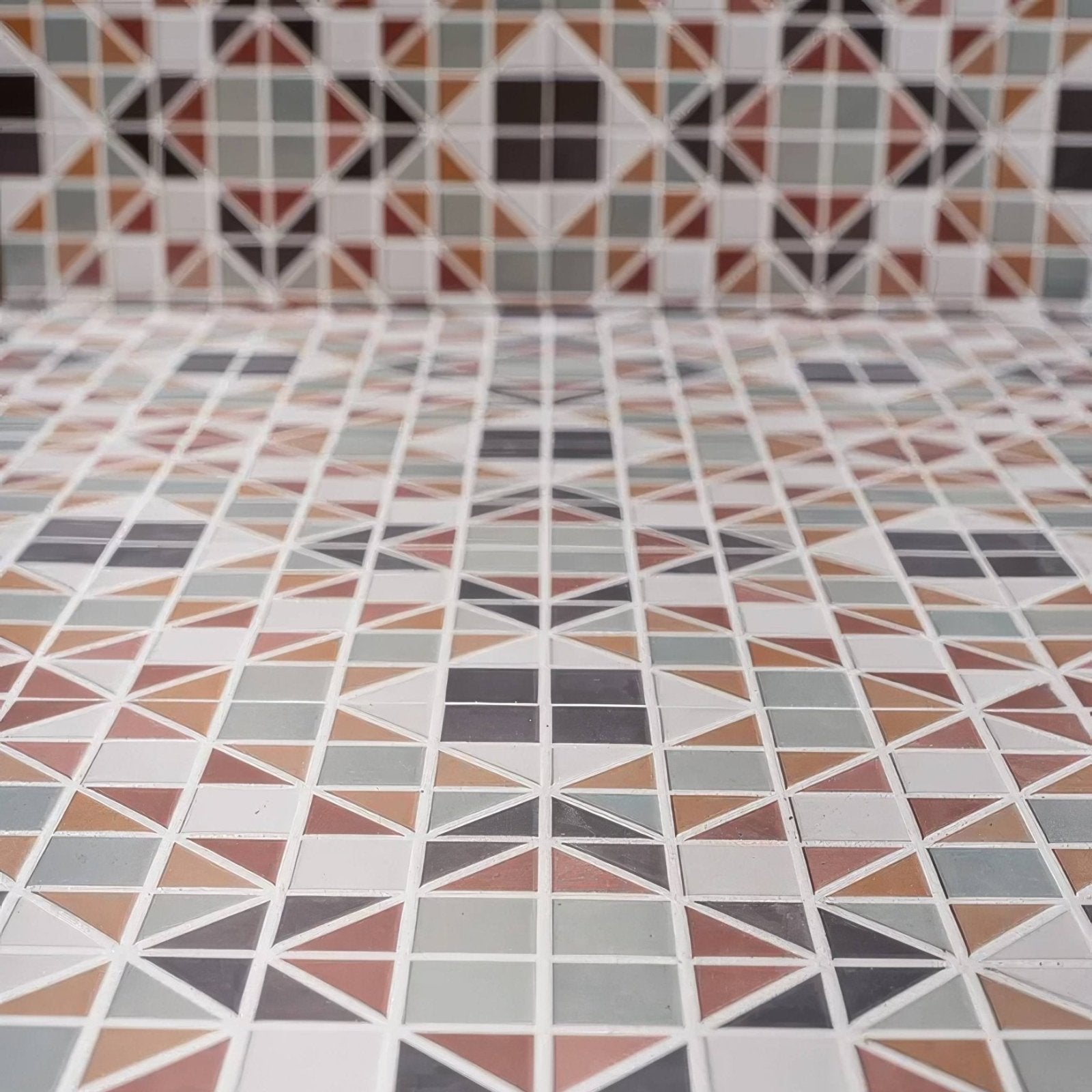 Geometric mosaic pavilion porcelain russet red tile floor with triangular and square muted earth tone patterns