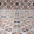 Geometric mosaic pavilion porcelain russet red tile floor with triangular and square muted earth tone patterns