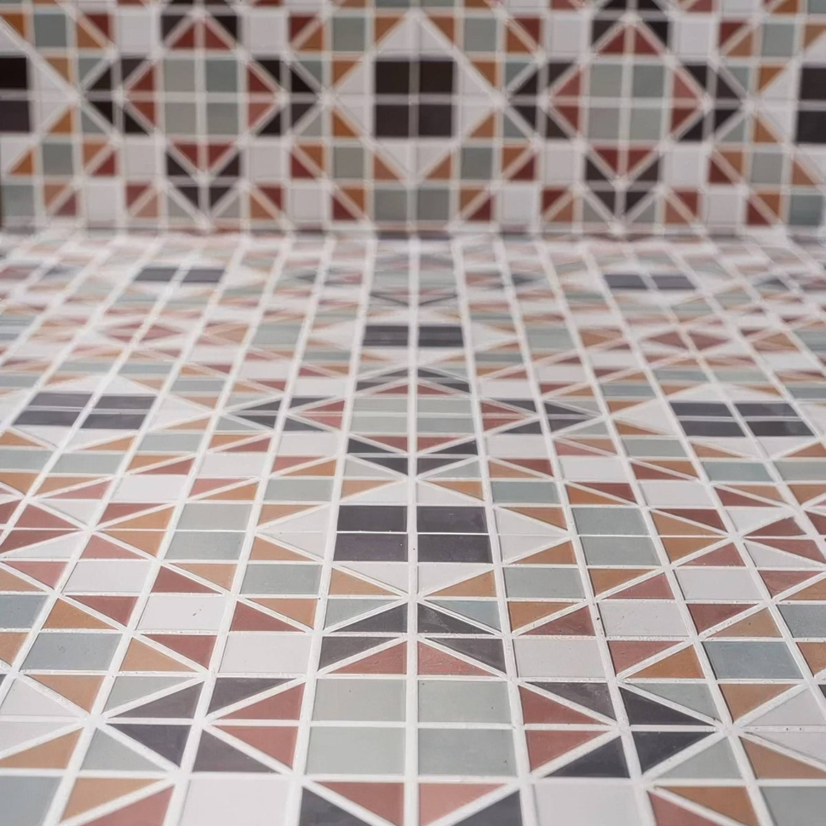 Geometric mosaic pavilion porcelain russet red tile floor with triangular and square muted earth tone patterns