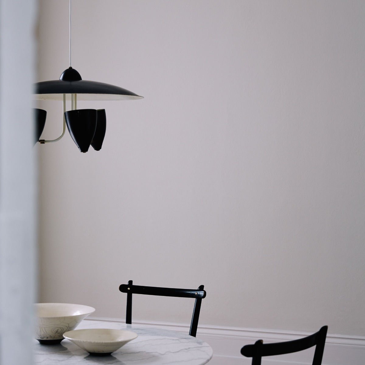 Black pendant lamp pearl ashes with three sleek conical shades and minimalist hanging design for modern interiors