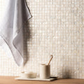 A white pearl shell mosaic tile wall with square shape and subtle iridescent sheen for decorative use