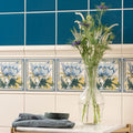Clear glass vase holding white and purple flowers on a peony single tile in county white background