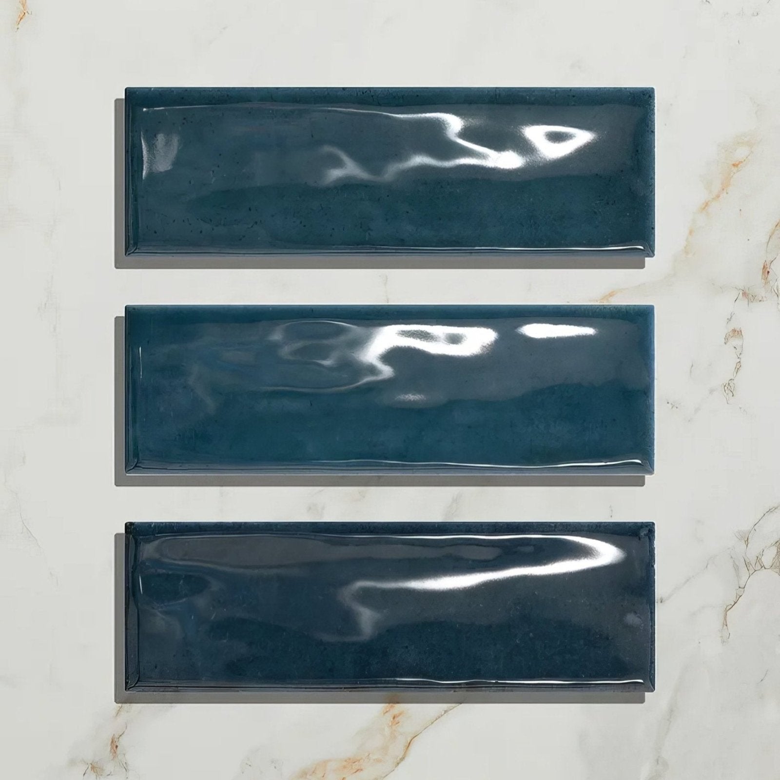 Three glossy teal rectangular porcelain tiles arranged vertically from petite porcelain gloss blue collection