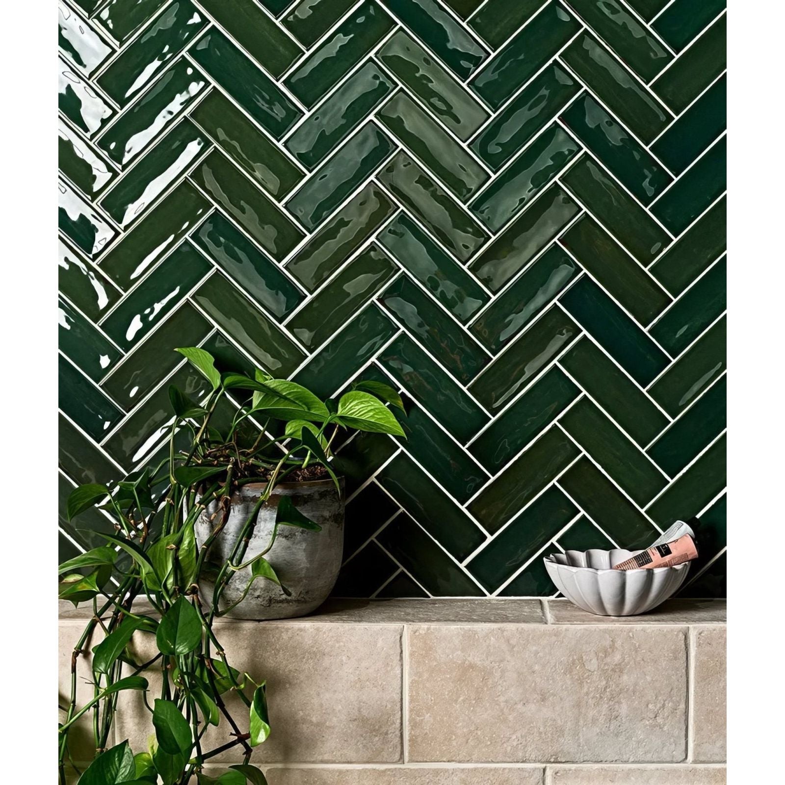 Petite porcelain gloss green dark green glossy rectangular tiles arranged in a herringbone pattern with white grout