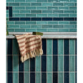 A soft beige and terracotta striped towel with fringed edges on a marble ledge for petite porcelain gloss sky