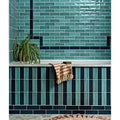 Petite porcelain gloss sky subway tiles with glossy teal and navy blue finish arranged in alternating horizontal rows