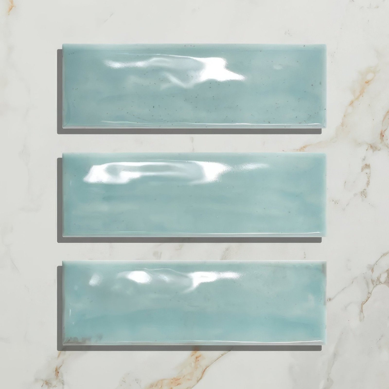 Three glossy turquoise petite porcelain gloss sky ceramic tiles arranged vertically for wall or surface use