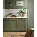 Petite porcelain gloss white kitchen cabinets with olive green shaker-style doors brass knobs and marble countertop