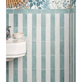 Vertical stripes of matte-finished teal and white petite porcelain matt white ceramic tiles on a bathroom wall