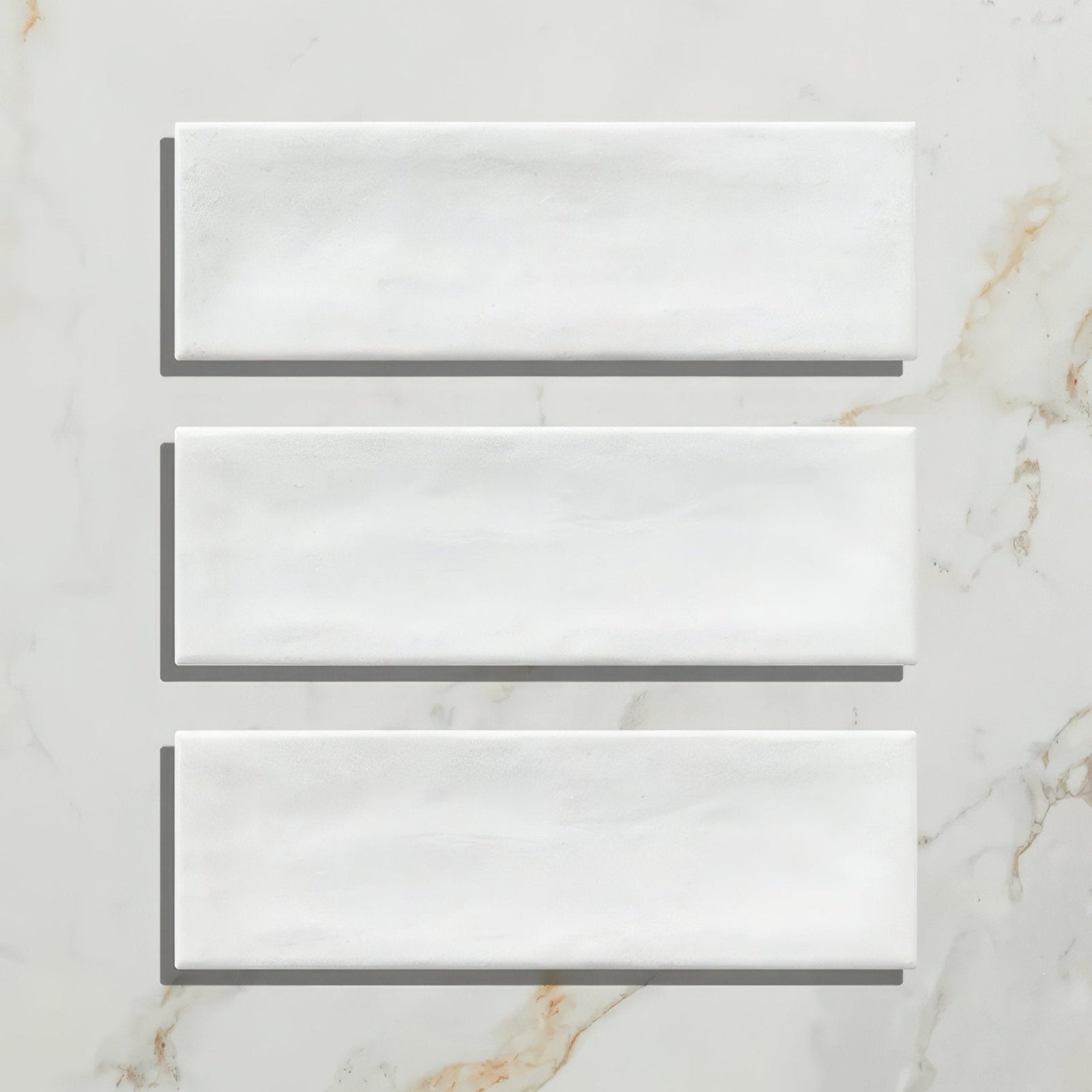 Three white porcelain subway tiles with a matt finish and subtle marble texture petite porcelain matt white