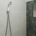 Chrome finished showerhead with white ceramic handle and flexible metal hose mounted on tiled wall for piazza bone 60 x 60cm