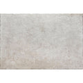A rectangular textured gray pierre porcelain gris stone tile with a subtle mottled pattern and uneven edges