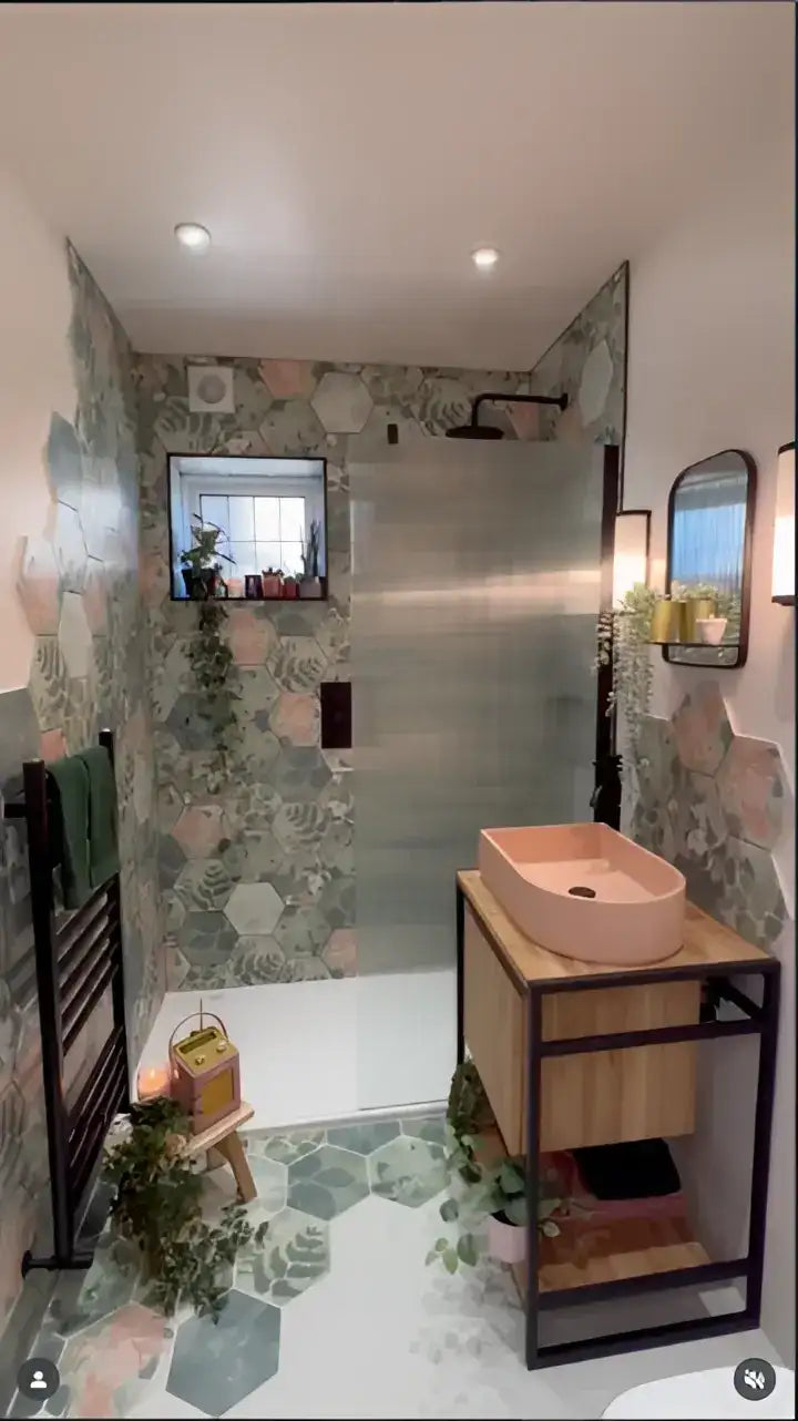 Pink ceramic vessel basin on a wood and black metal vanity in a finished bathroom.