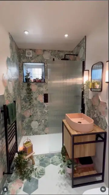 Pink ceramic vessel sink on a wooden and black metal vanity