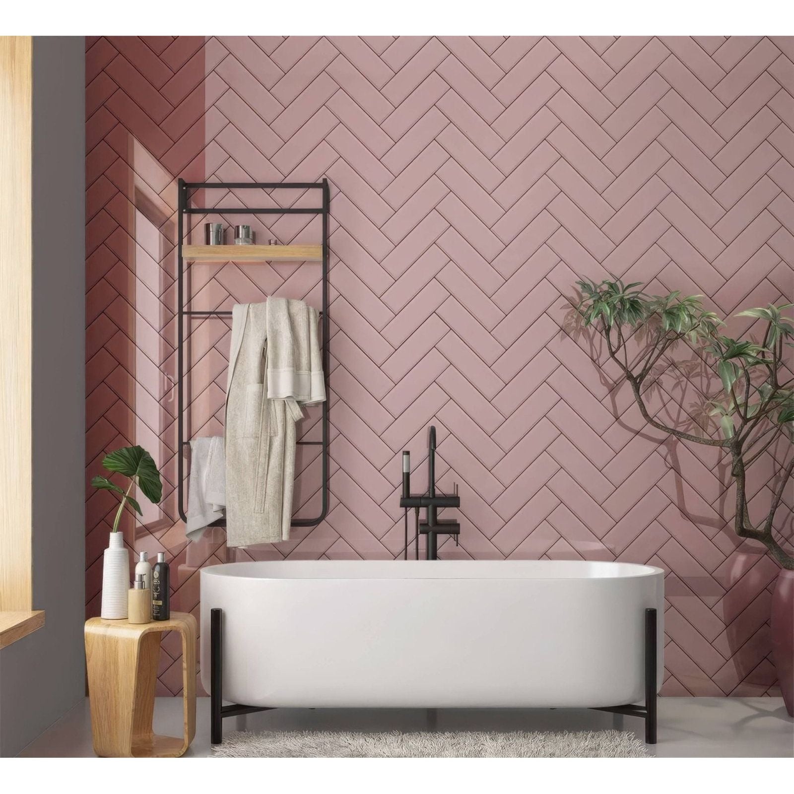 Modern freestanding bathtub with sleek white ceramic finish and minimalist black metal legs for a pink herringbone shower panel