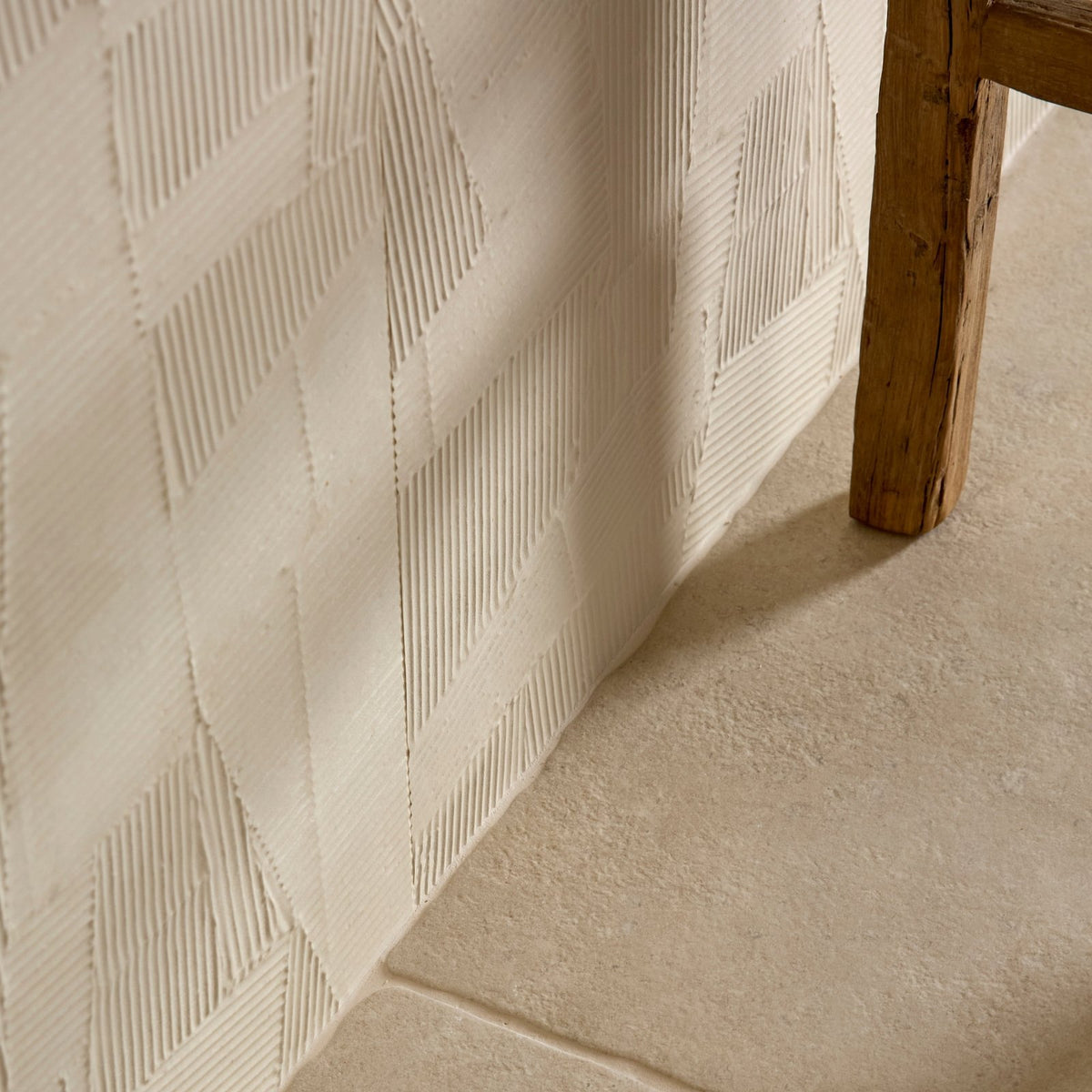 Cream-colored plastercraft calco porcelain sabbia textured wall panel with raised geometric diamond pattern