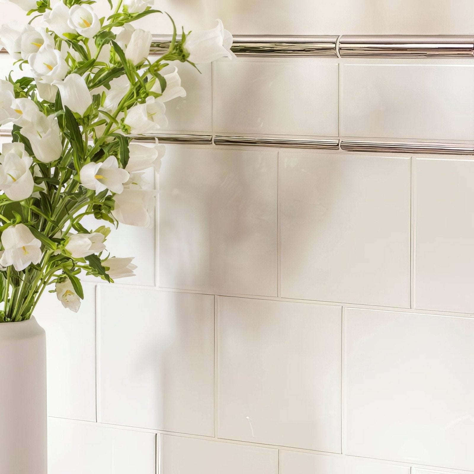 White ceramic vase with white bellflowers paired with platinum metallic omega moulding for elegant decor