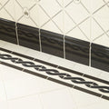 Plymouth border black baseboard with glossy ceramic finish and wavy braided design installed along a wall