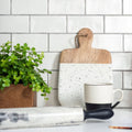 Half tile porcelain cutting board with white speckles natural wood handle and wooden edges for kitchen use