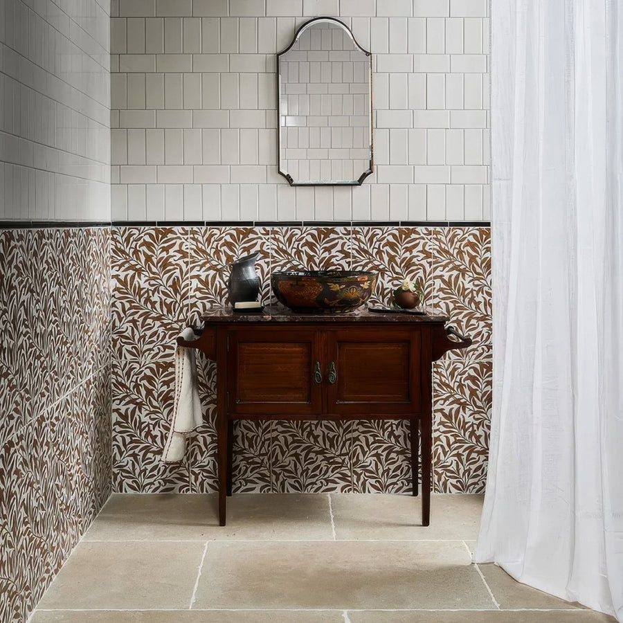 Dark wood vanity with two doors and ornate metal handles topped by polished marble surface in cotswold porcelain matt