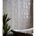 Silver metallic square hammam ceramic blue tiles with subtle textured finish covering the wall
