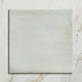 Square white marble tile with subtle veining and polished surface from hammam ceramic blue collection