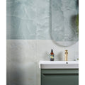 illusion Whisper Onyx Porcelain Polished Mist white marble-effect tiles with a sink and gold tap