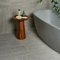 A sleek dark brown wooden Pembroke porcelain satin 60 x 60cm pedestal table with polished finish and natural wood grain