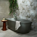 Modern matte gray freestanding bathtub with sleek oval design and towel draped over edge in pembroke porcelain satin finish