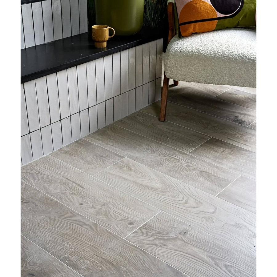 Gray wood-grain vinyl plank flooring with natural textured finish in parterre porcelain plank design