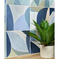 A green agave plant in a textured light gray concrete-style porcelain pot titled rio porcelain