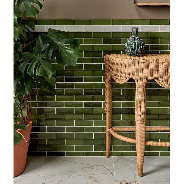 Soprano Porcelain 60 x 120cm cream marble-effect tiles with a green ceramic vase on a wicker table