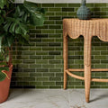Soprano Porcelain 60 x 60cm cream marble-effect tiles with a green ceramic vase on a wicker table