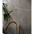 Modern matte gray marble-effect treviso porcelain matt wall tiles 59.5 x 120cm with brushed brass faucet and bamboo leaves