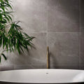 Treviso Porcelain Matt 59.5 x 59.5cm grey marble-effect tiles with a freestanding bathtub and brass tap