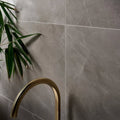Treviso Porcelain Matt 59.5 x 59.5cm grey marble-effect tiles with a gold tap