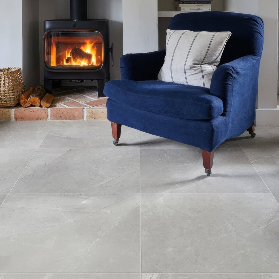 Treviso Porcelain Matt 59.5 x 59.5cm grey marble-effect tiles with a blue velvet armchair