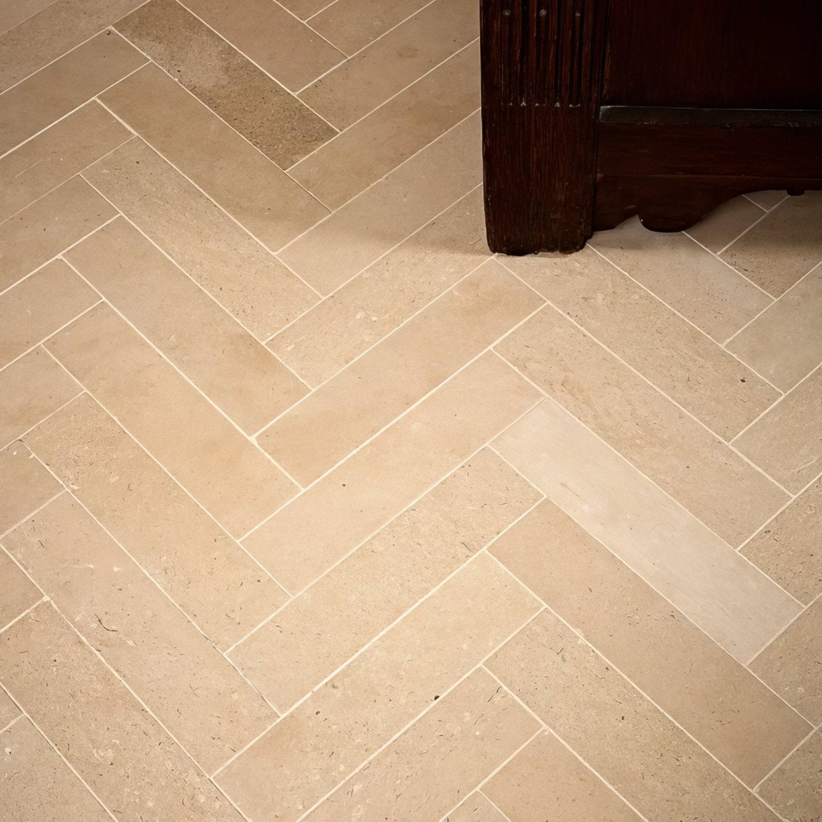 Beige rectangular portland limestone honed parquet tiles arranged in a herringbone pattern for flooring