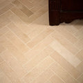 Beige rectangular portland limestone honed parquet tiles arranged in a herringbone pattern for flooring