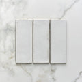 Three white rectangular porcelain tiles arranged side by side on a marble surface for pottery natural cotton brick