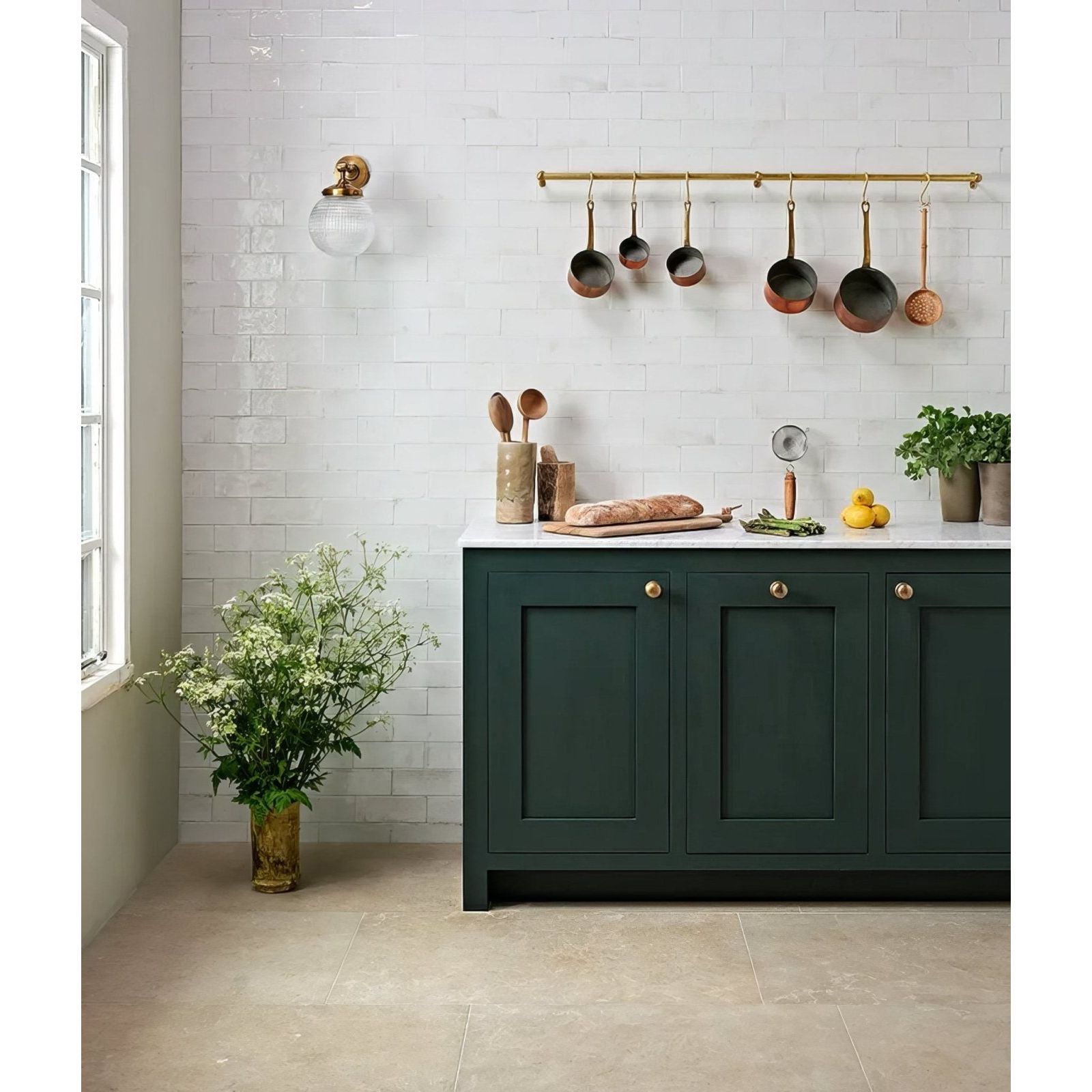 Dark green kitchen cabinet with gold-toned knobs and white countertop featuring pottery porcelain natural cotton brick design
