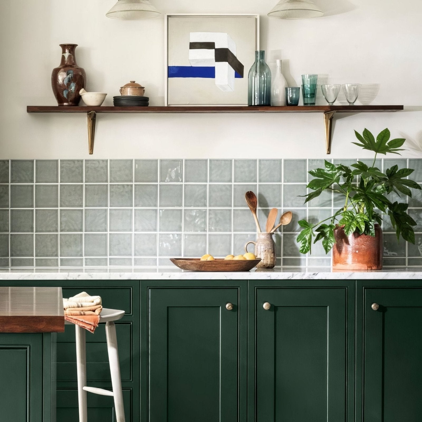 Dark green paneled kitchen cabinets with silver round knobs and white marble countertop in provence falicon square design
